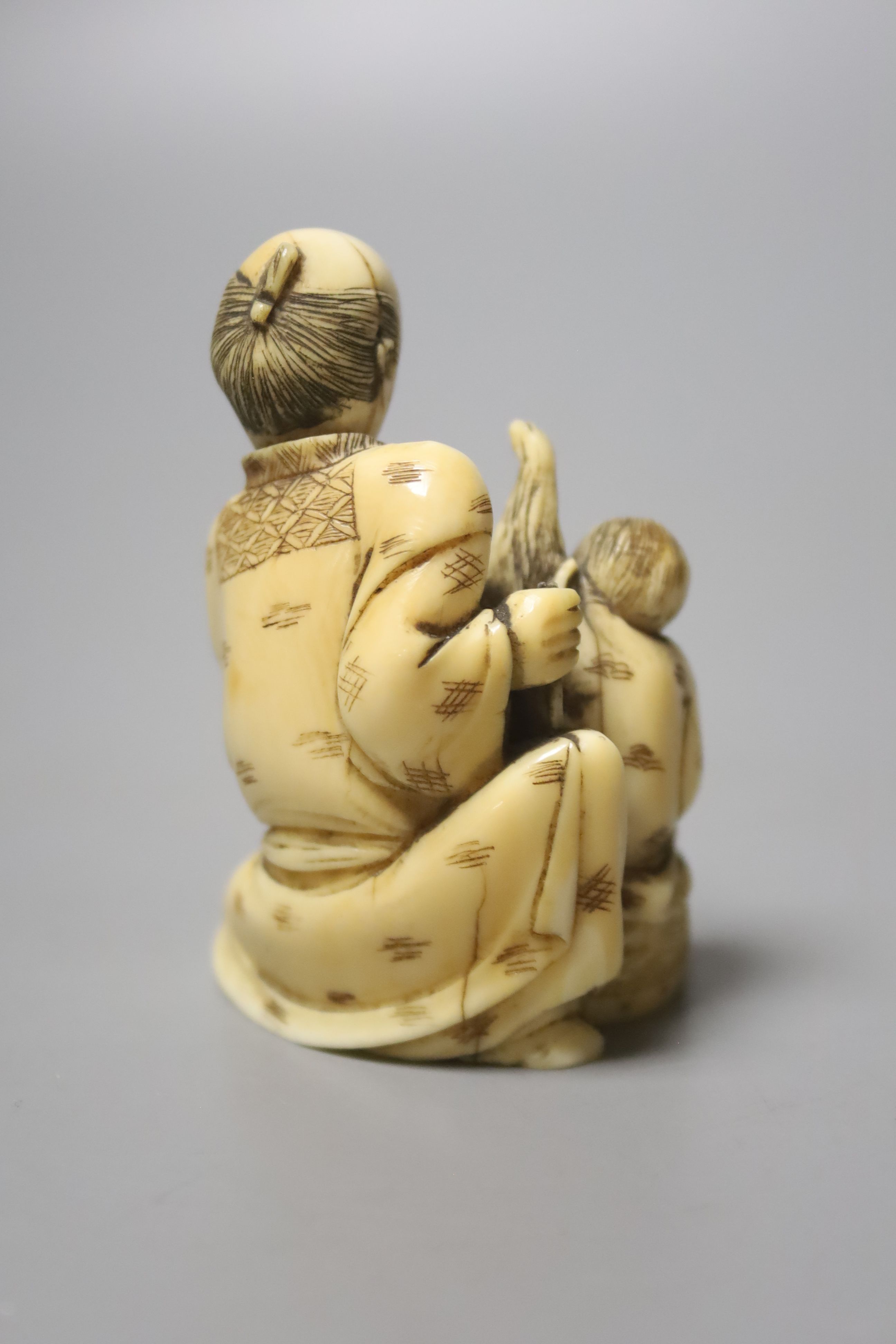 A Japanese ivory group of a man with a monkey, 19th century, 6.5cm high